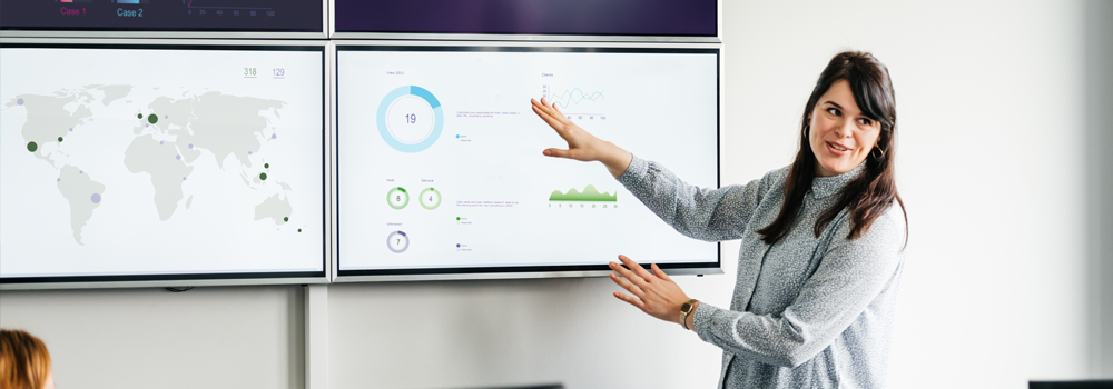 Image of Businesswoman Explaining Graphs And Data Displayed On Large Monitors
